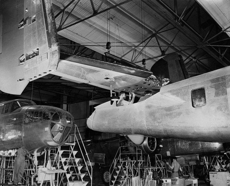 00 Tail assembly for a North American B-25 is lowered into place from an overhead crane on the...jpg