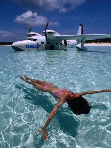 greg-johnston-female-floating-in-crystal-waters-in-front-of-seaplane-bahamas.jpg