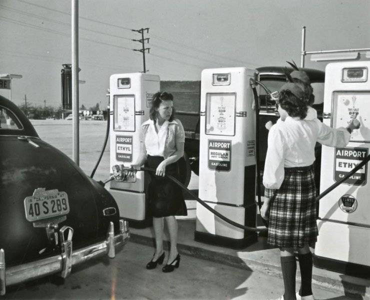 Service - Lady pumps her own AIRPORT gas while two uniformed attendants stand by, California, ...jpg