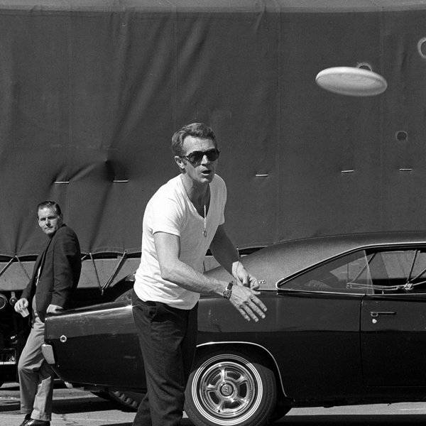 Steve McQueen playing frizbee in-front of the Villion Black 68 Charger on set.jpg